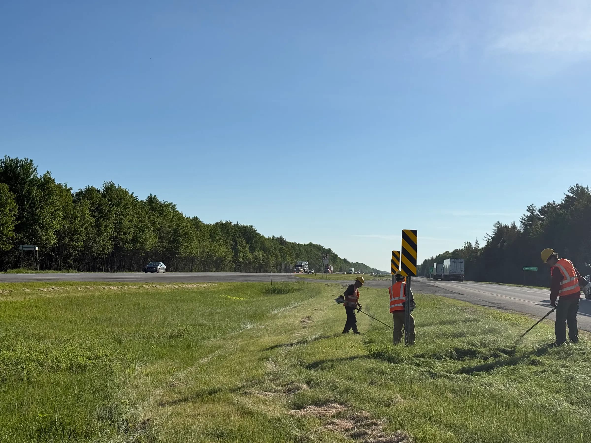 Équipe de F.A.D.S. à la débroussailleuse le long d'une autoroute